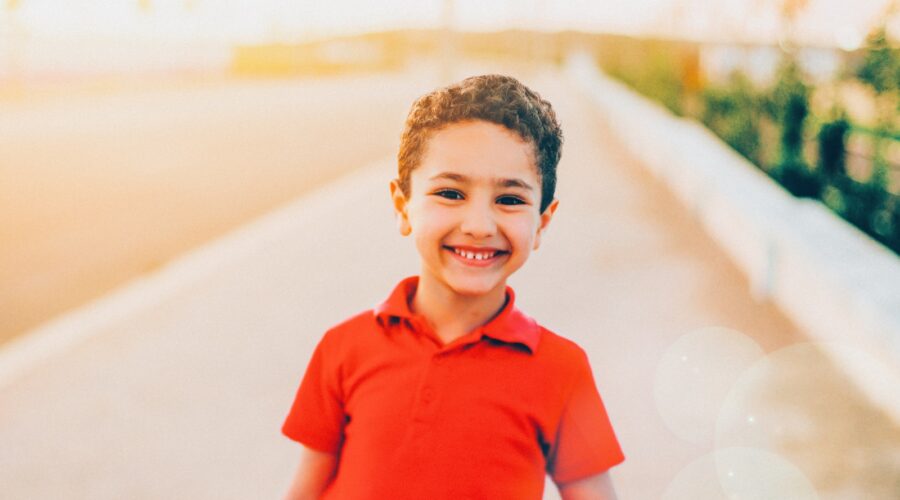smiling boy wearing red polo shirt